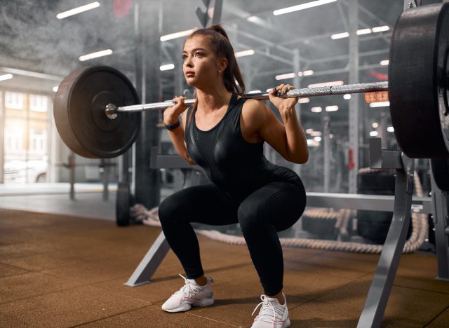 woman doing squats with weight