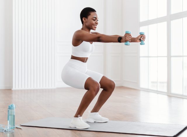 woman doing squat with dumbbells