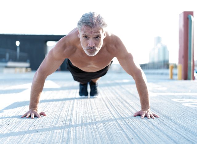 man in his 50s doing push-up on cement