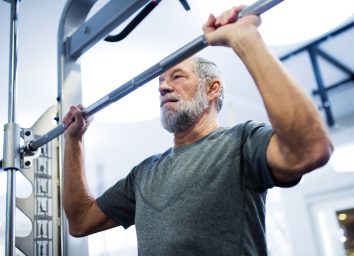 older man getting ready to lift weights