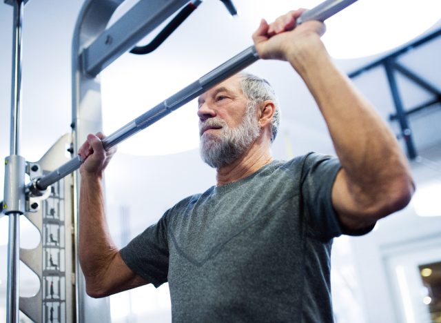 older man getting ready to lift weights