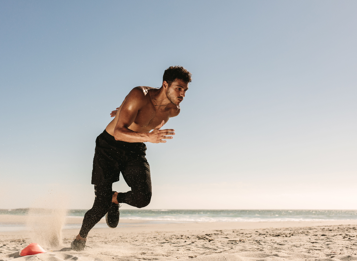 man sprinting at the beach