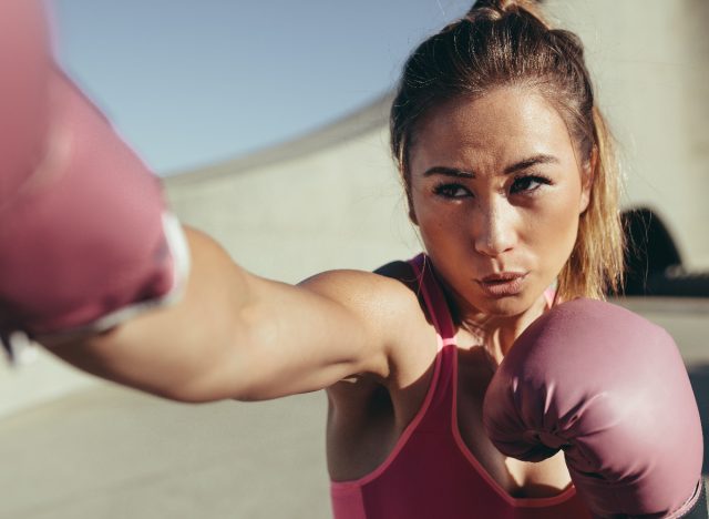 woman boxing outdoors with pink gloves