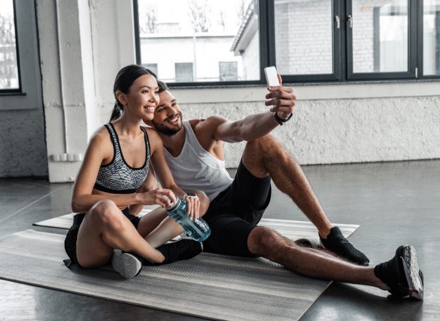 couple taking a workout picture on yoga mats