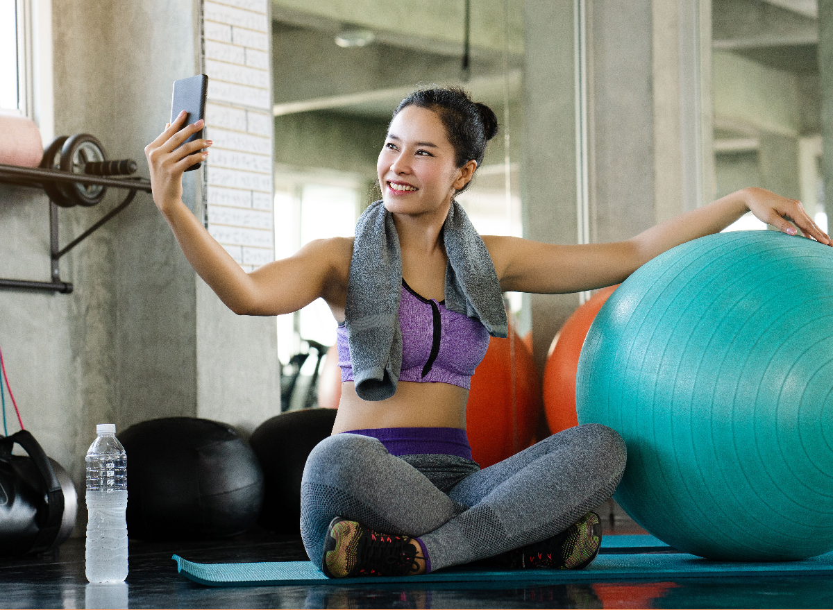 woman snapping workout picture next to exercise ball