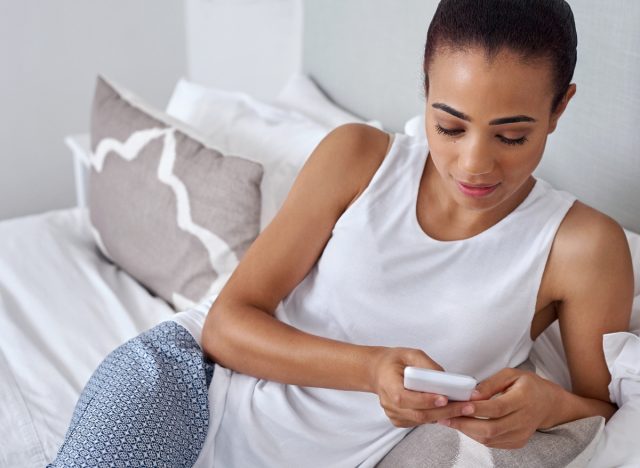 woman texting in bed