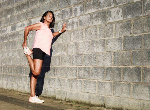 woman stretching getting ready to perform wall pushup