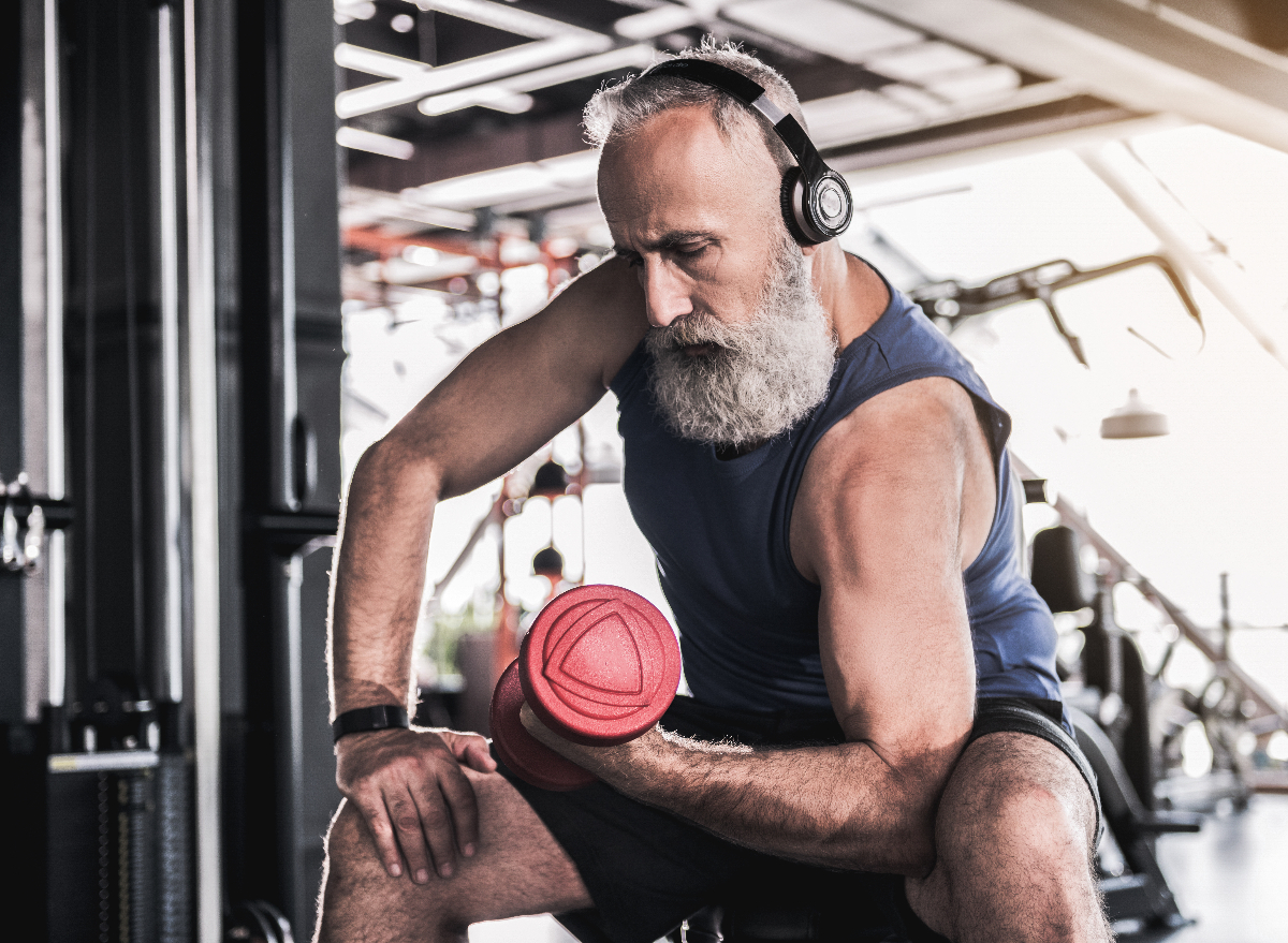 older man lifting weight in gym workout