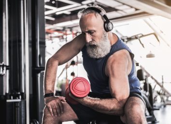 older man lifting weight in gym workout