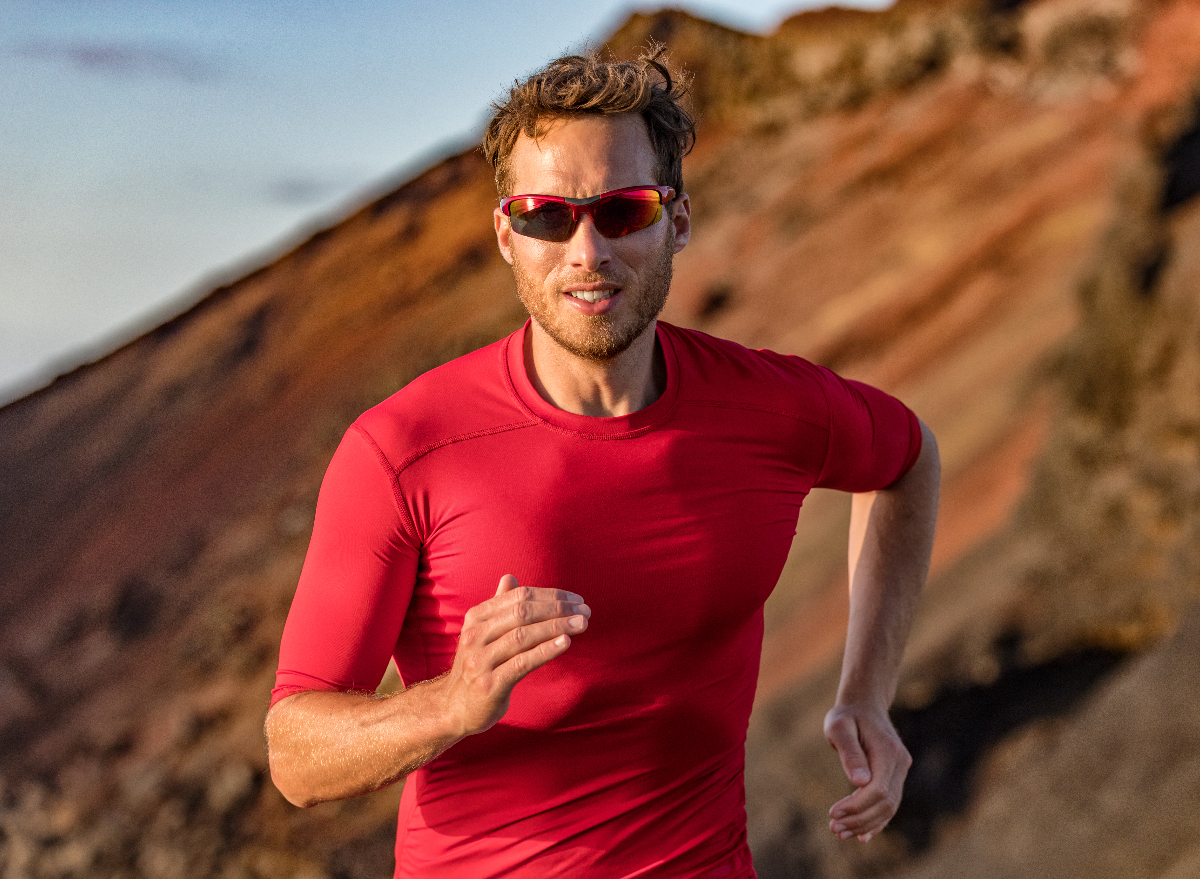 man runs in desert in red workout clothing