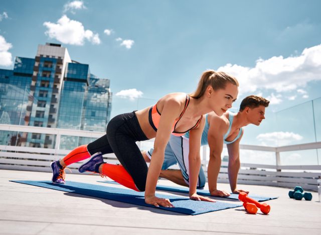 couple does rooftop workout in athletic clothing