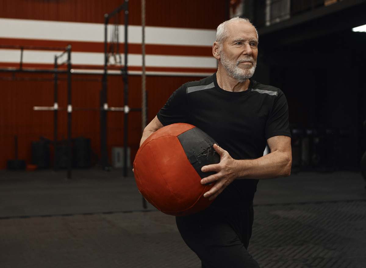 man does workout in gym with exercise ball during the best time to work out