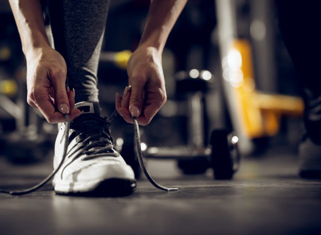 close-up of woman tying gym sneakers