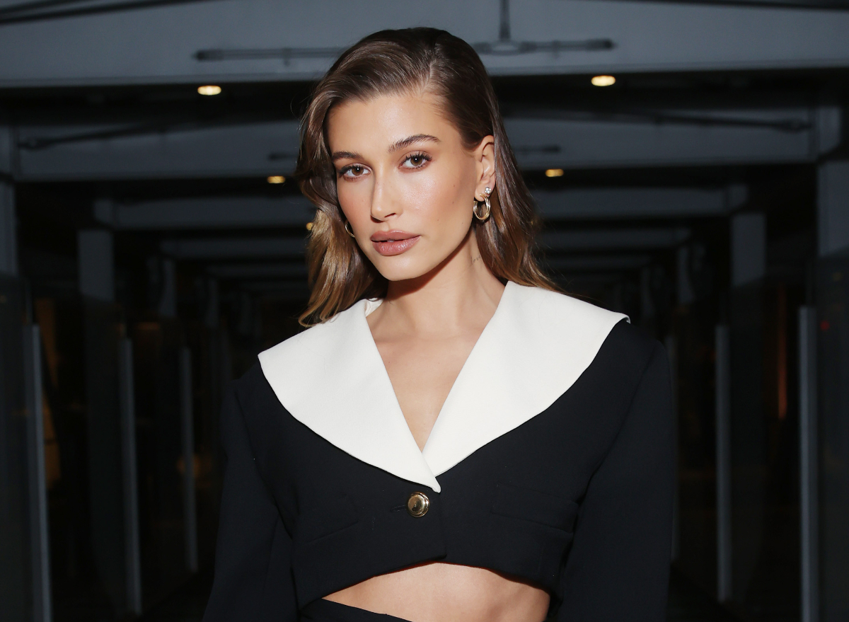 hailey bieber poses at event in black and white ensemble, glazed donut skin routine