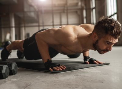 man performing pushup on yoga mat