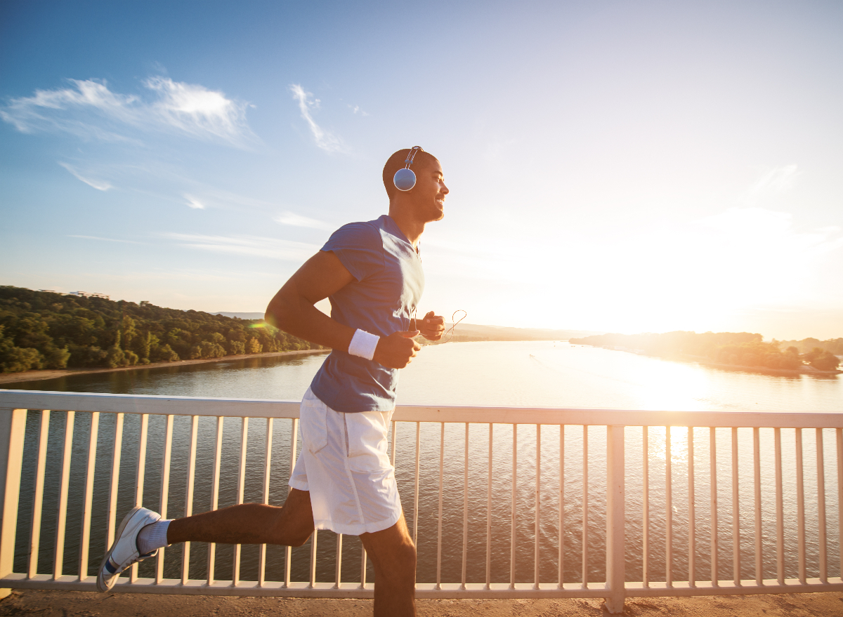 man running across bridge on sunny summer day