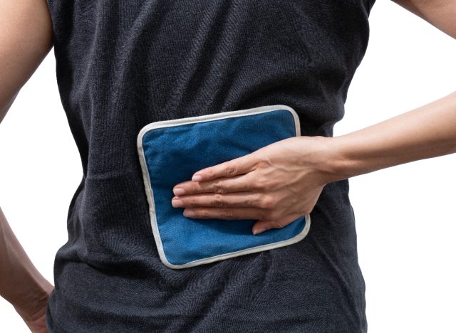 woman putting ice pack on back