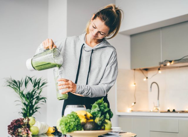 woman making a green smoothie