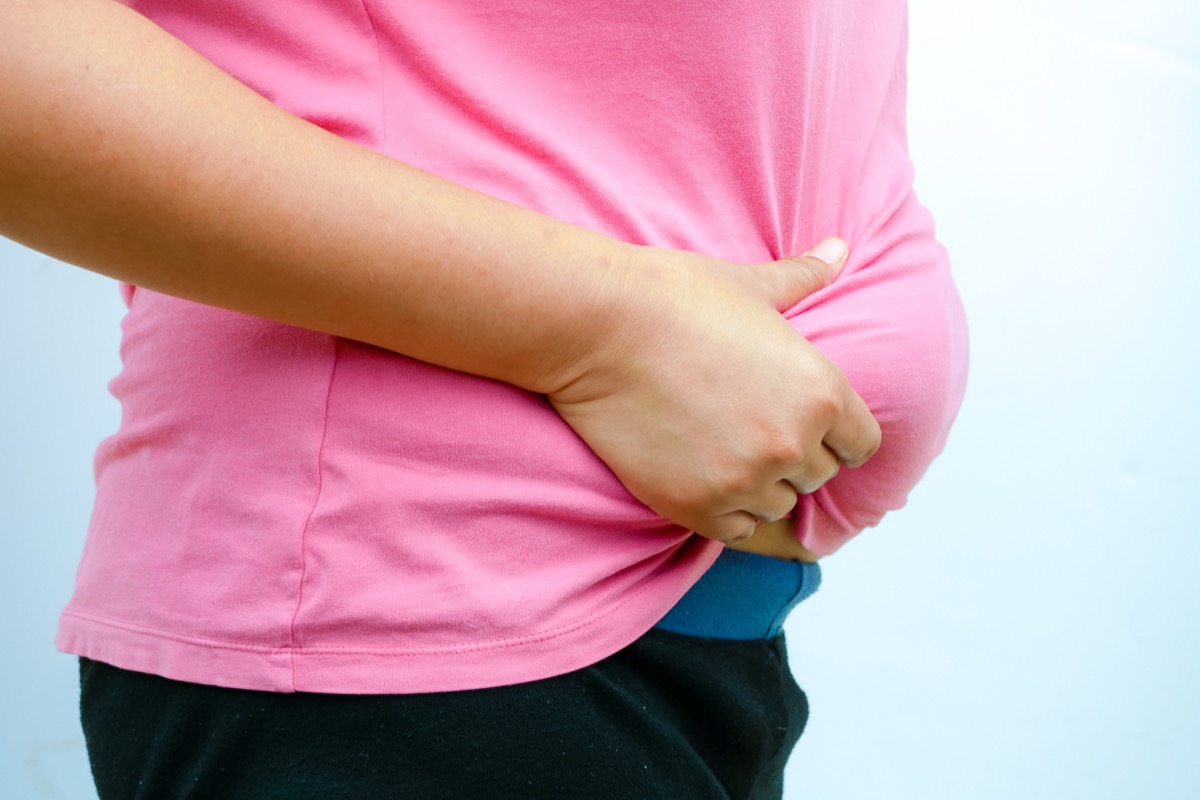 The woman squeeze her tummy.