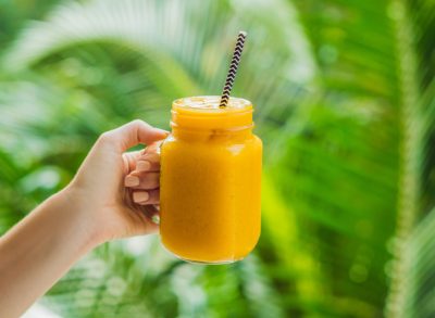 holding mango smoothie