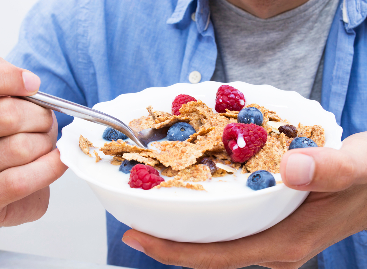 man eating cereal with berries