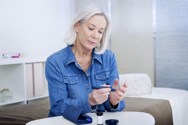 Senior woman checking her blood glucose level.