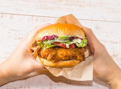 person holding fried chicken sandwich