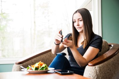 Young diabetic woman checking her blood sugar levels.