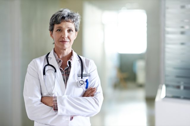 Portrait of a mature female doctor standing in a hospital.