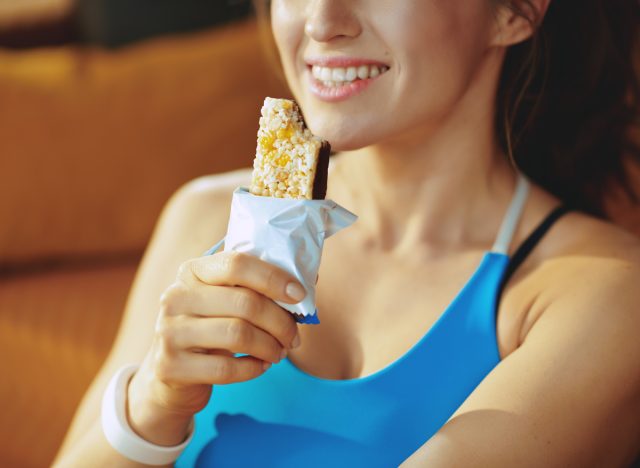 woman eating protein bar, concept of weight loss mistakes