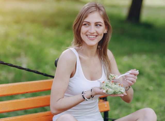 woman eating salad outdoors