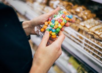 woman holding bag of candy in a grocery store