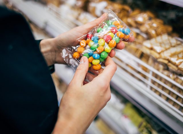 woman holding bag of candy in a grocery store