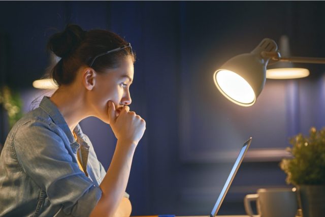 woman working on laptop next to light
