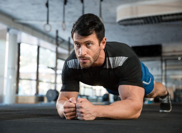 serious athletic man performing plank