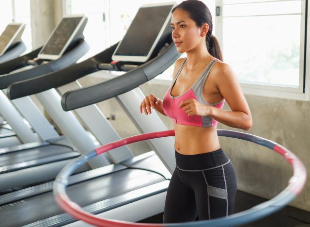 woman exercising with weighted hula hoop