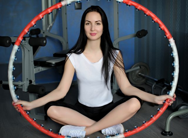 Woman sitting on the floor with a hula hoop