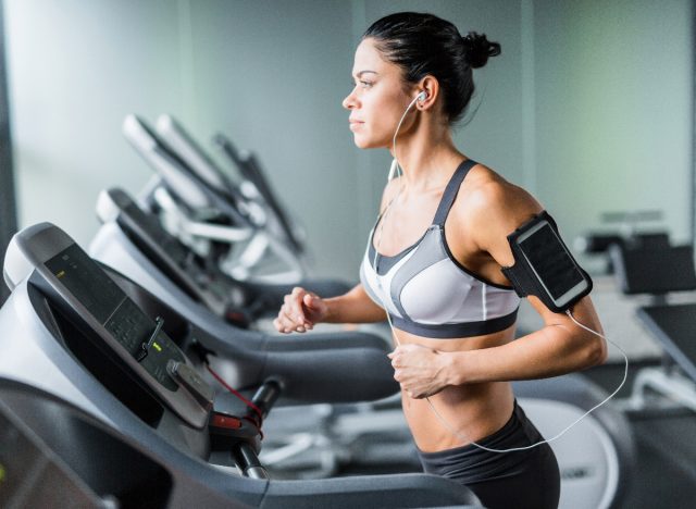 fit woman exercising at gym doing incline cardio workout on treadmill