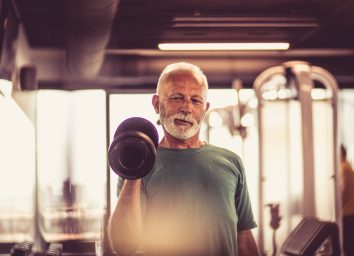senior man exercising with weights to prevent bone loss
