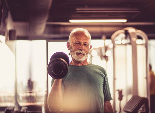 Пожилой мужчина тренируется с отягощениями, чтобы предотвратить потерю костной массы