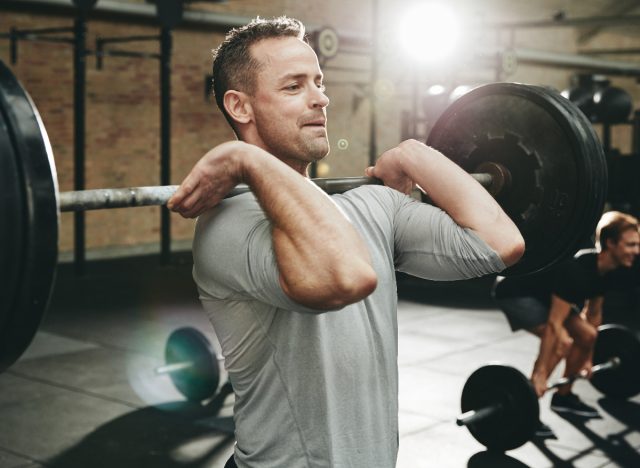 man lifts weights in gym