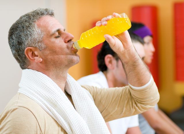 man having energy drink during workout to manage low blood sugar