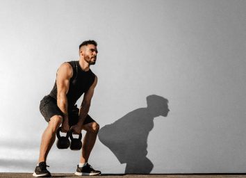 man working out with kettlebells