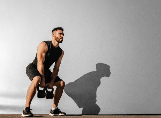 man working out with kettlebells