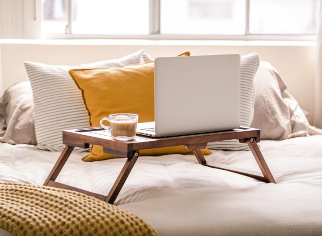 desk in bed with coffee and laptop on it