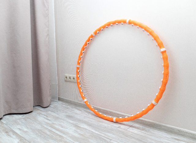 orange weighted hula hoop against wall