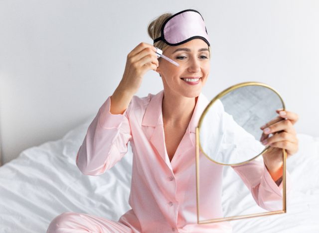 a woman who applies serum to her face