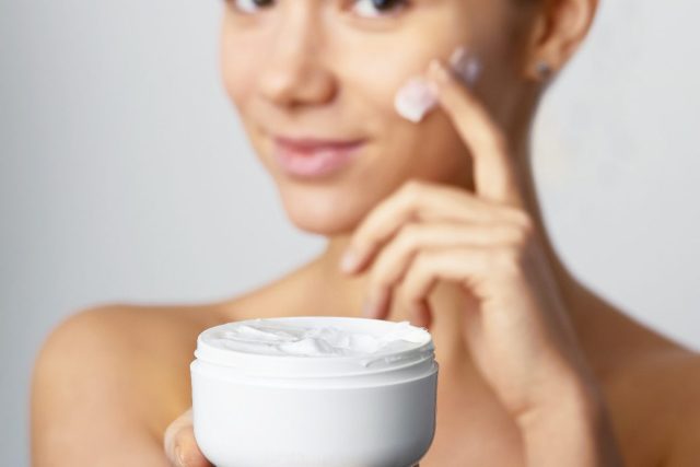 woman applying face lotion