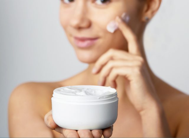 woman applies face lotion