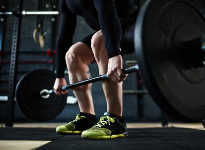 close-up man's sneakers while lifting barbell training